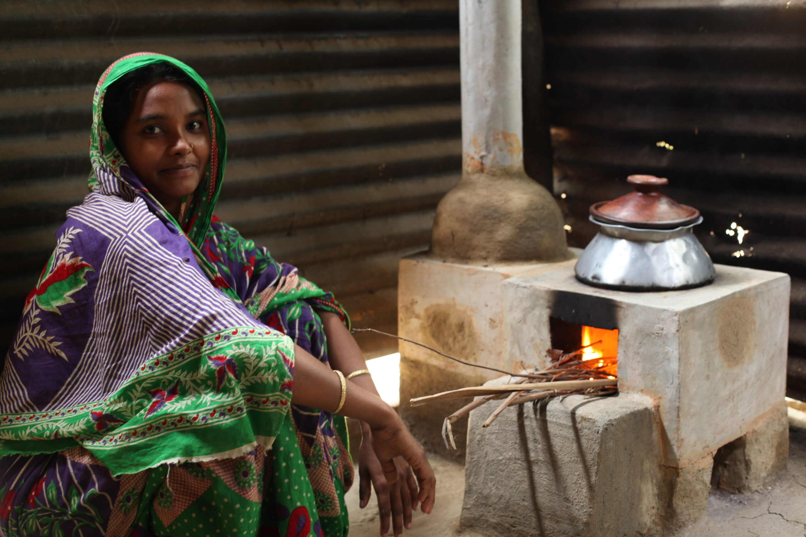 A metalworker prepares the shell of a Gyapa cookstove